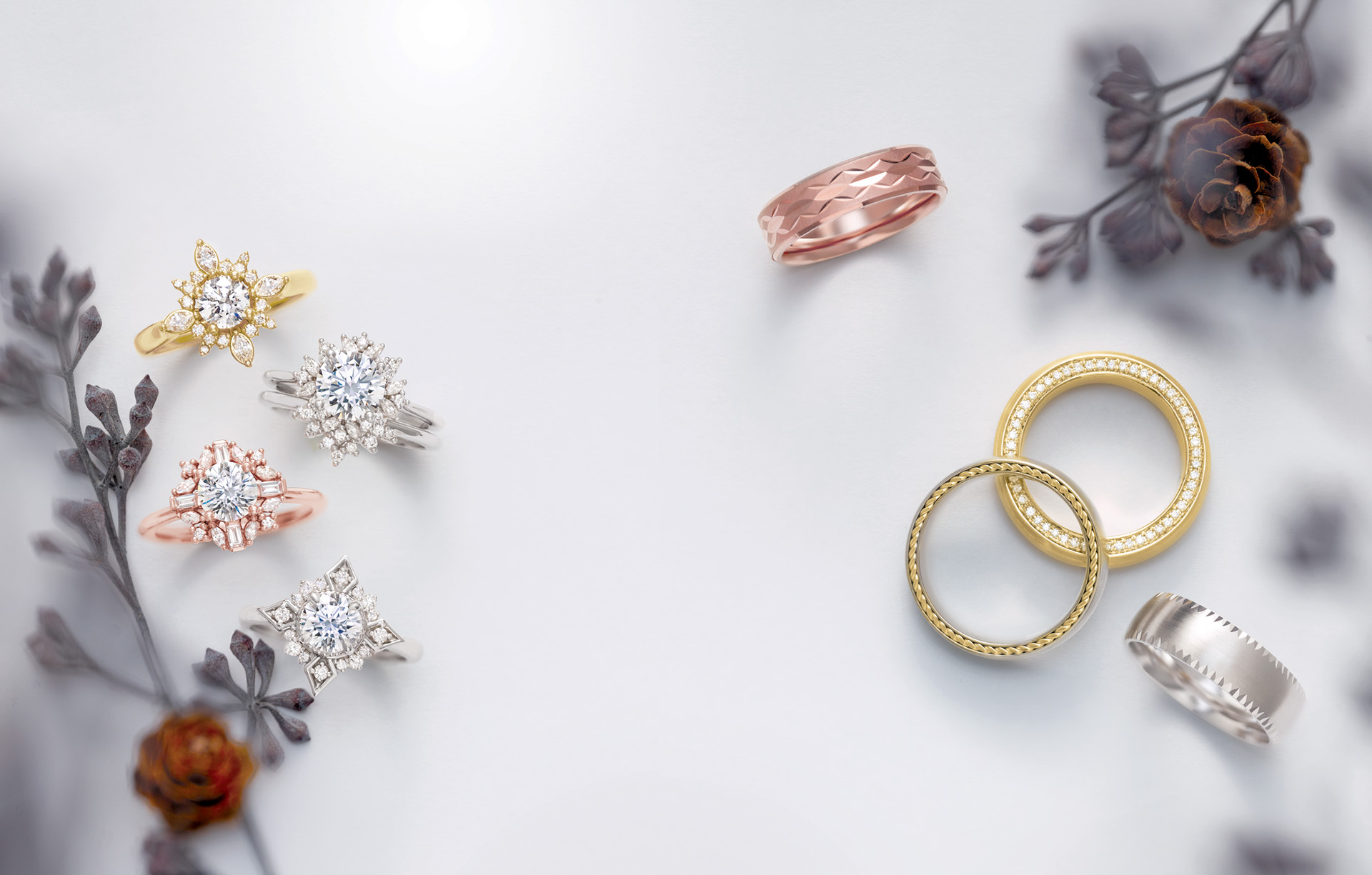 white background with winter pinecone twigs and diamond rings and wedding bands